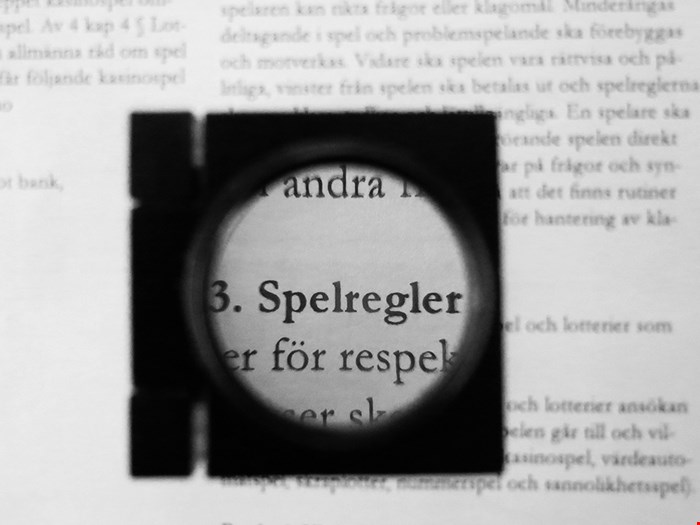 Förstoringsglas som visar spelord i ett lexikon